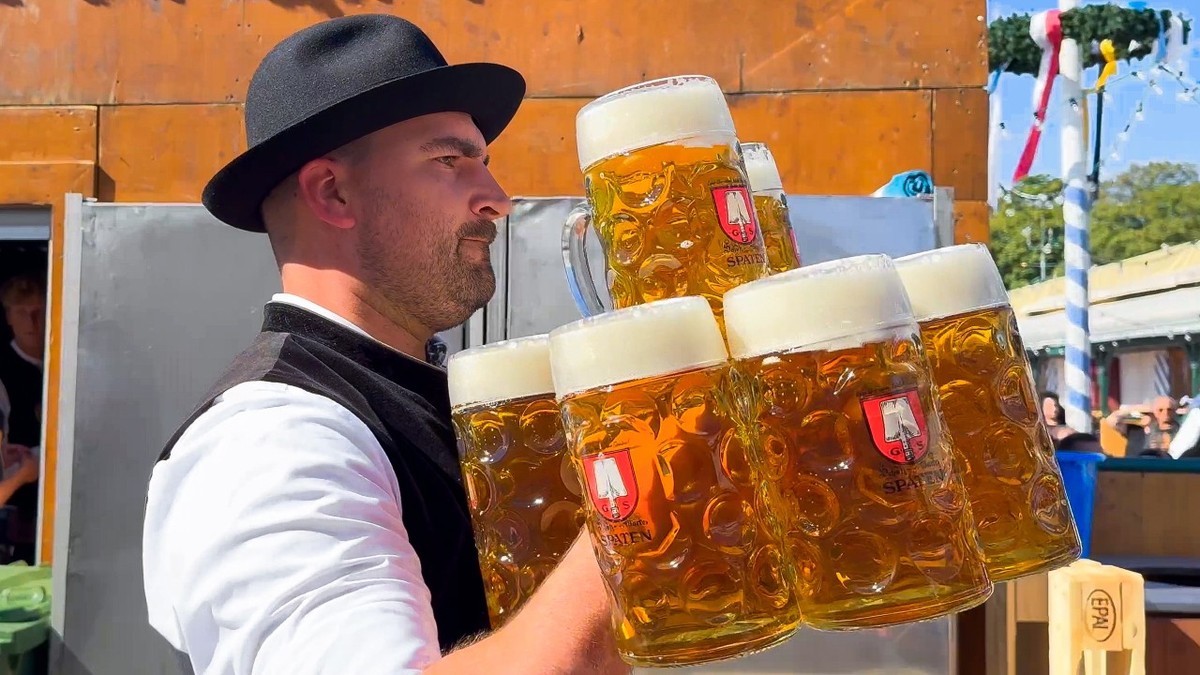 Chelner care transportă halbe de bere la Oktoberfest, München, Germania, 21 septembrie 2024.