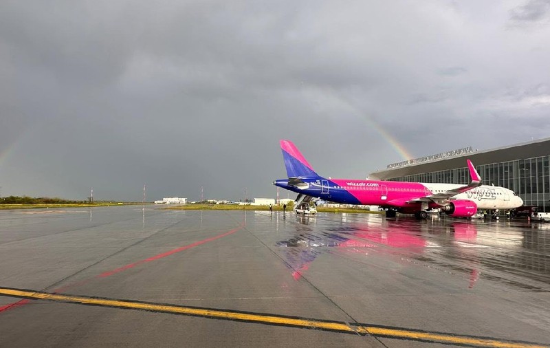 aeronavă wizz air pe aeroportul din Craiova, într-o zi înnorată, se vede curcubeul