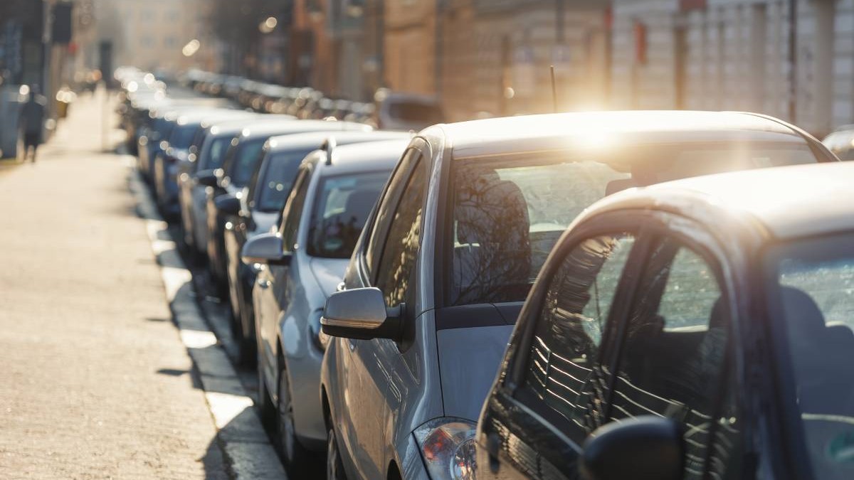 mai multe masini parcate in linie, langa un trotuar