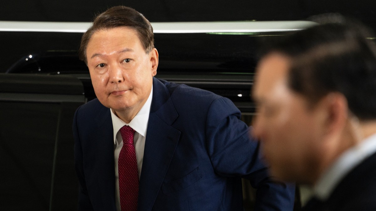 Yoon Suk Yeol, fostul președinte sud-coreean, îmbrăcat în costum, iese dintr-o mașină