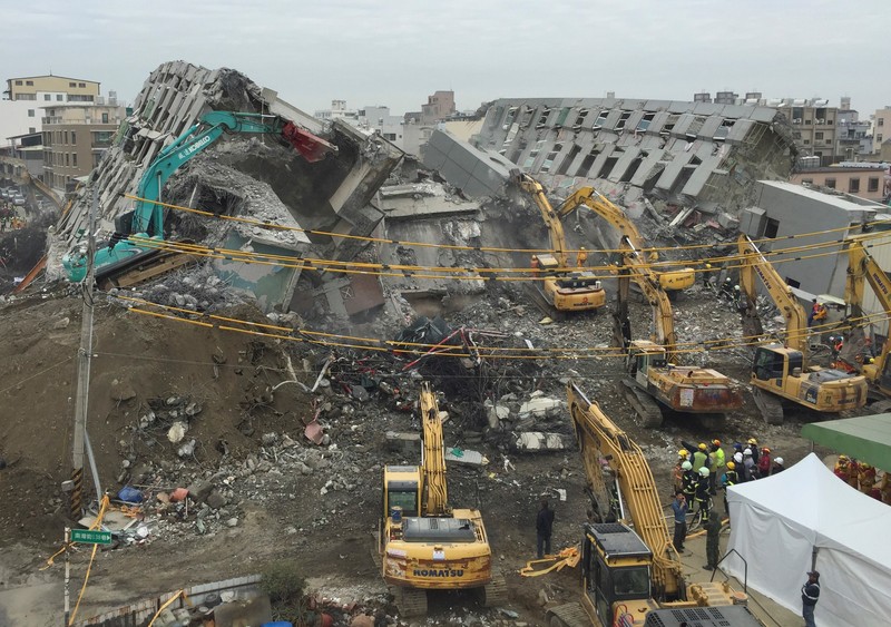 Rescue workers using excavators continue to search the rubble of a collapsed building complex in Tainan, Taiwan, Wednesday, Feb. 10, 2016. The Tainan District Prosecutors Office said in a statement Wednesday that they have approved the detention of three construction company executives who are suspected to have overseen shoddy construction of the 17-story Weiguan Golden Dragon building, which tumbled on to its side following an earthquake Saturday.,Image: 583034944, License: Rights-managed, Restrictions: This content is intended for editorial use only. For other uses, additional clearances may be required., Model Release: no