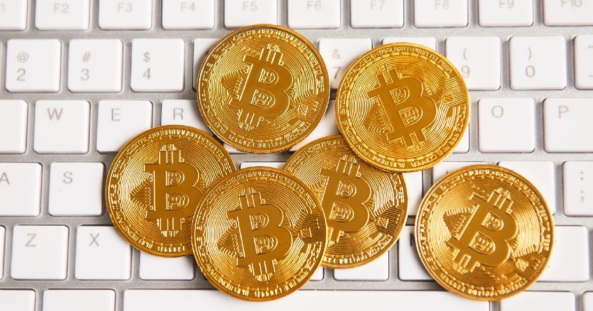 Monede aurii Bitcoin pe o tastaura alba