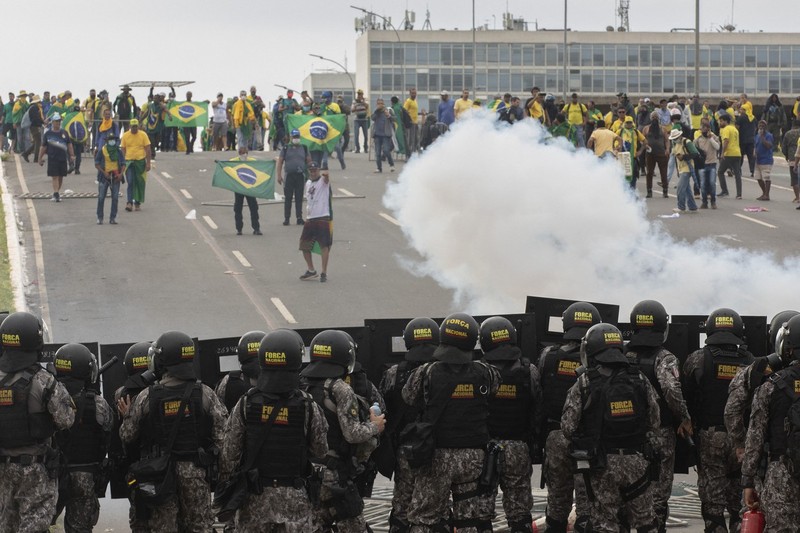 Susținători ai fostului președinte Jair Bolsonaro se ciocnesc cu forțele de securitate, pe 8 ianuarie, în Brazilia. Poliția a intervenit cu gaze lacrimogene pentru a-i dispersa pe protestatarii pro-Bolsonaro. Foto: Profimedia