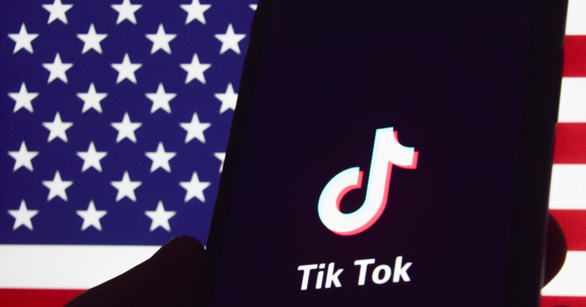 logo-ul aplicației tiktok afișat pe ecranul negru al unui telefon mobil, în fața steagului americii