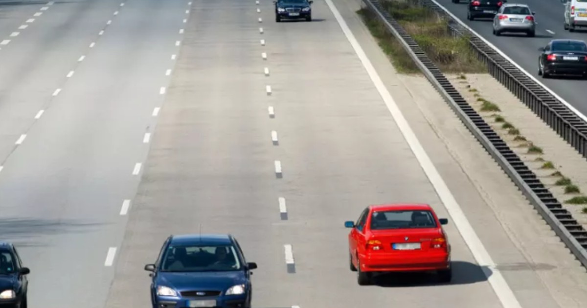O mașină roșie care circulă pe contrasens, pe o autostradă.