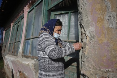 Femeia se chinuie să intre în casa ei din satul Greci