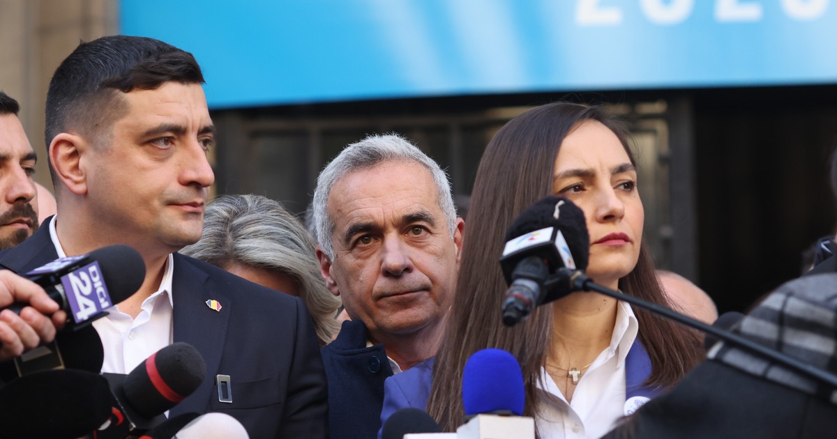 Doi bărbați și o femeie stau în fața mai multor microfoane