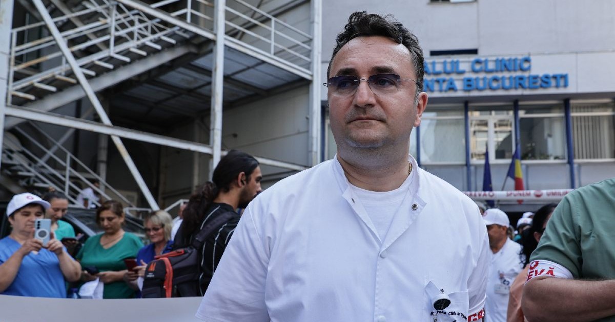 Un medic imbracat in halat in fata spitalului Floreasca in greva de avertisment. Garzile sa fie platite corect.