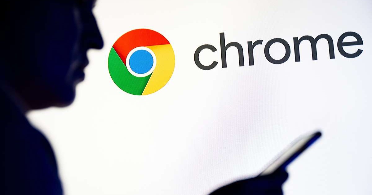 Silueta unui bărbat cu smartphone-ul în mână, în fața logo-ului Google Chrome afișat pe un fundal alb.
