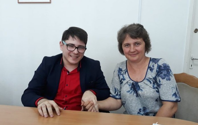 Mama care îl însoțește permanent la școală pe fiul ei. E paralizat în scaunul cu rotile dar are media 9.22