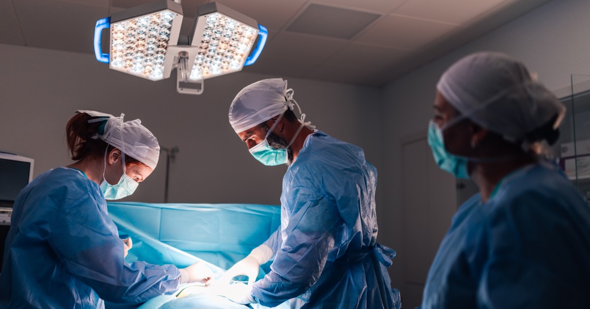 Mai mulți medici într-o sală de operație, în timp ce tratează un pacient