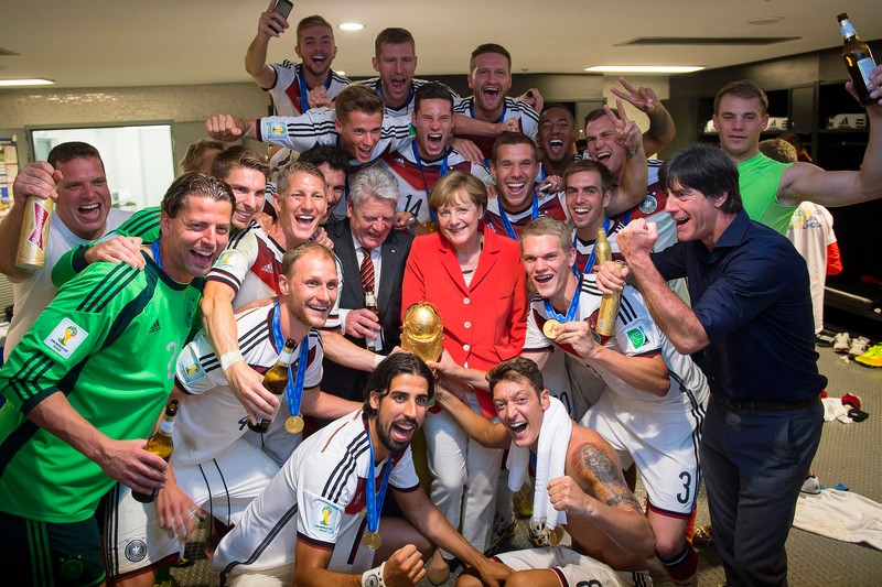 epa04315185 A handout picture provided by the German Federal Press Office of German Chancellor Angela Merkel (C) celebrating with German national soccer team players after the FIFA World Cup 2014 final between Germany and Argentina at the Estadio do Maracana in Rio de Janeiro, Brazil, 13 July 2014. Germany won 1-0 after extra time. (RESTRICTIONS APPLY: Editorial Use Only, not used in association with any commercial entity - Images must not be used in any form of alert service or push service of any kind including via mobile alert services, downloads to mobile devices or MMS messaging - Images must appear as still images and must not emulate match action video footage - No alteration is made to, and no text or image is superimposed over, any published image which: (a) intentionally obscures or removes a sponsor identification image; or (b) adds or overlays the commercial identification of any third party which is not officially associated with the FIFA World Cup) EPA/GUIDO BERGMANN HANDOUT EDITORIAL USE ONLY/NO SALES