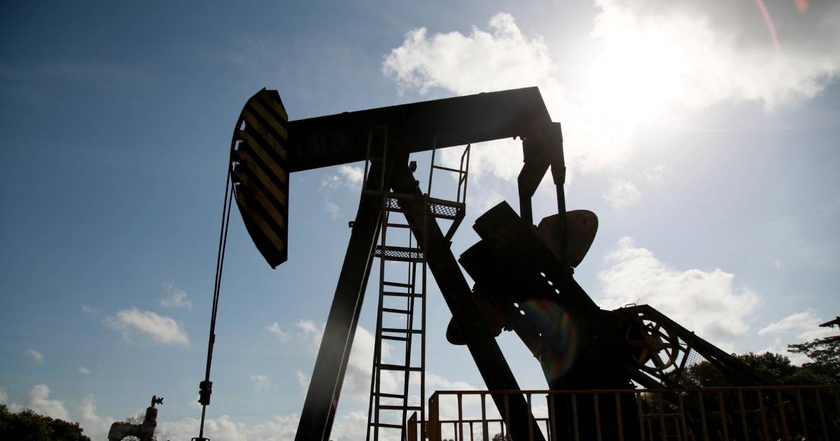 O pompă de extracție a petrolului este vizibilă la răsărit, în câmpul petrolier din Cabimas. Foto: Jose Bula.