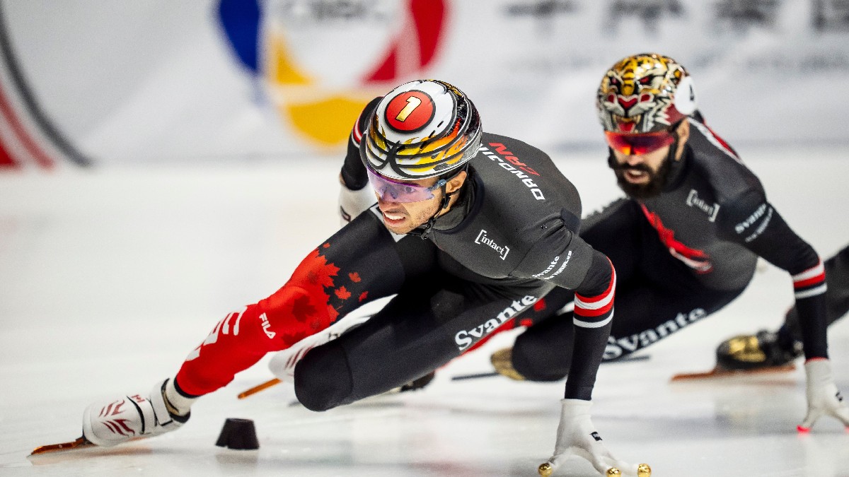 Două persoane patinează în timpul finalei masculine de 1000 de metri de la Circuitul Mondial de Patinaj Viteză
