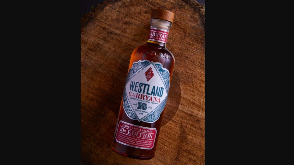 O sticlă de whiskey Westland Garryana stă culcată pe o masă maro de lemn