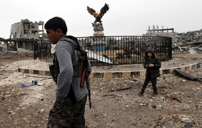 Un membru al Unității de Protecție a Poporului Kurd (YPG) , prin ruinele orașului Kobane, în septembrie 2015, după ce ISIS a fost înfrânt | Foto: EPA