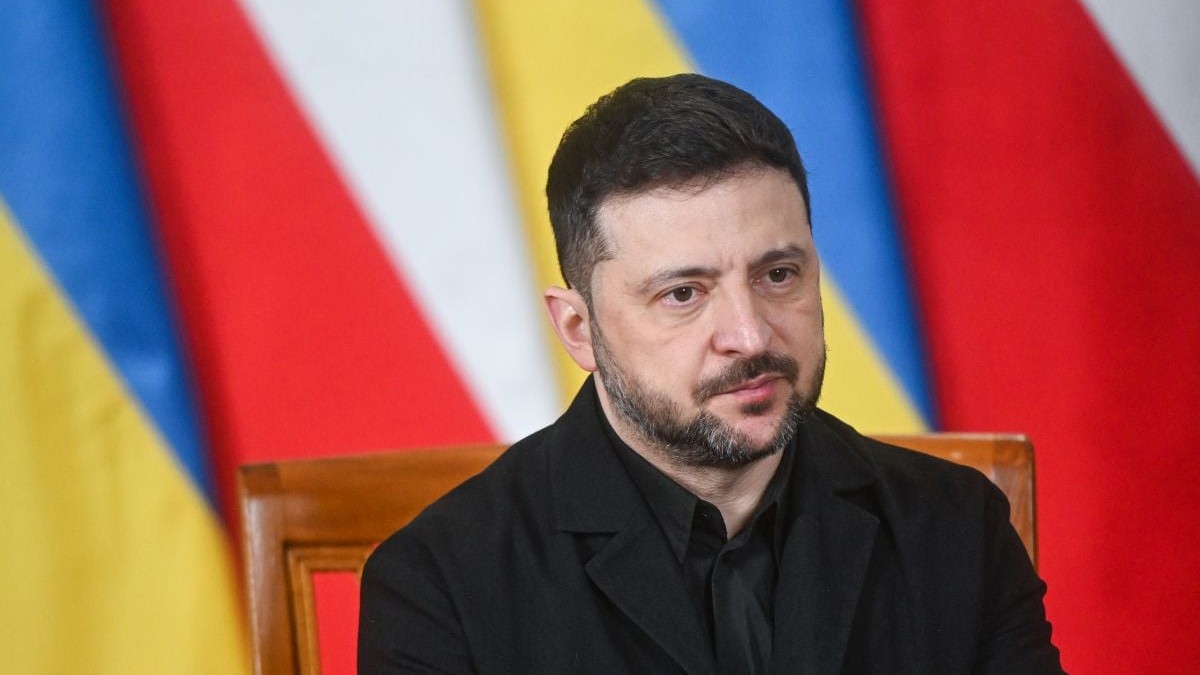 Volodimir Zelenski, având pe fundal steagurile Poloniei și Ucrainei, vorește în timpul unei conferințe de presă la Varșovia, 19 decembrie 2025