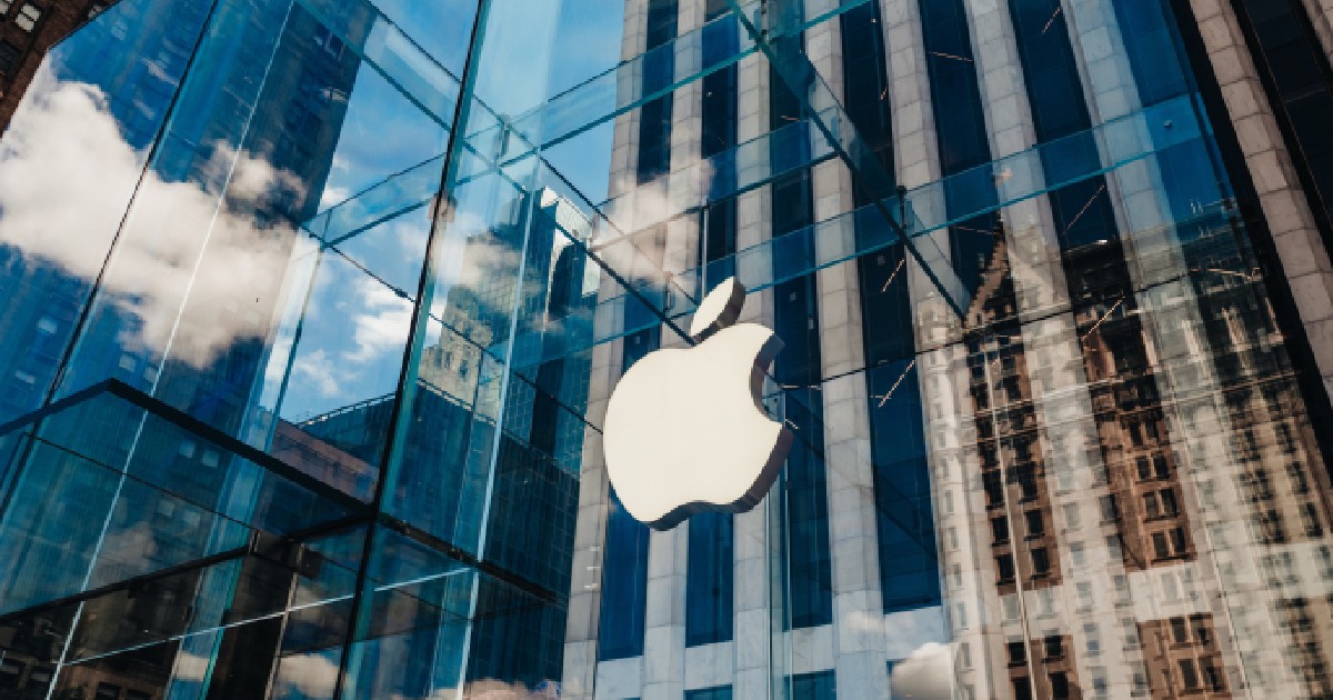 O clădire cu geamuri de sticlă pe care este logo-ul companiei Apple.