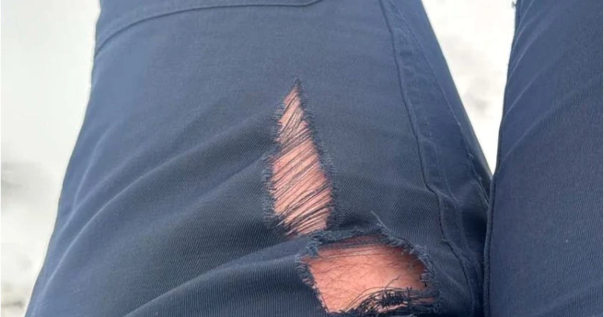 Pantaloni albaștri rupți în partea stângă.