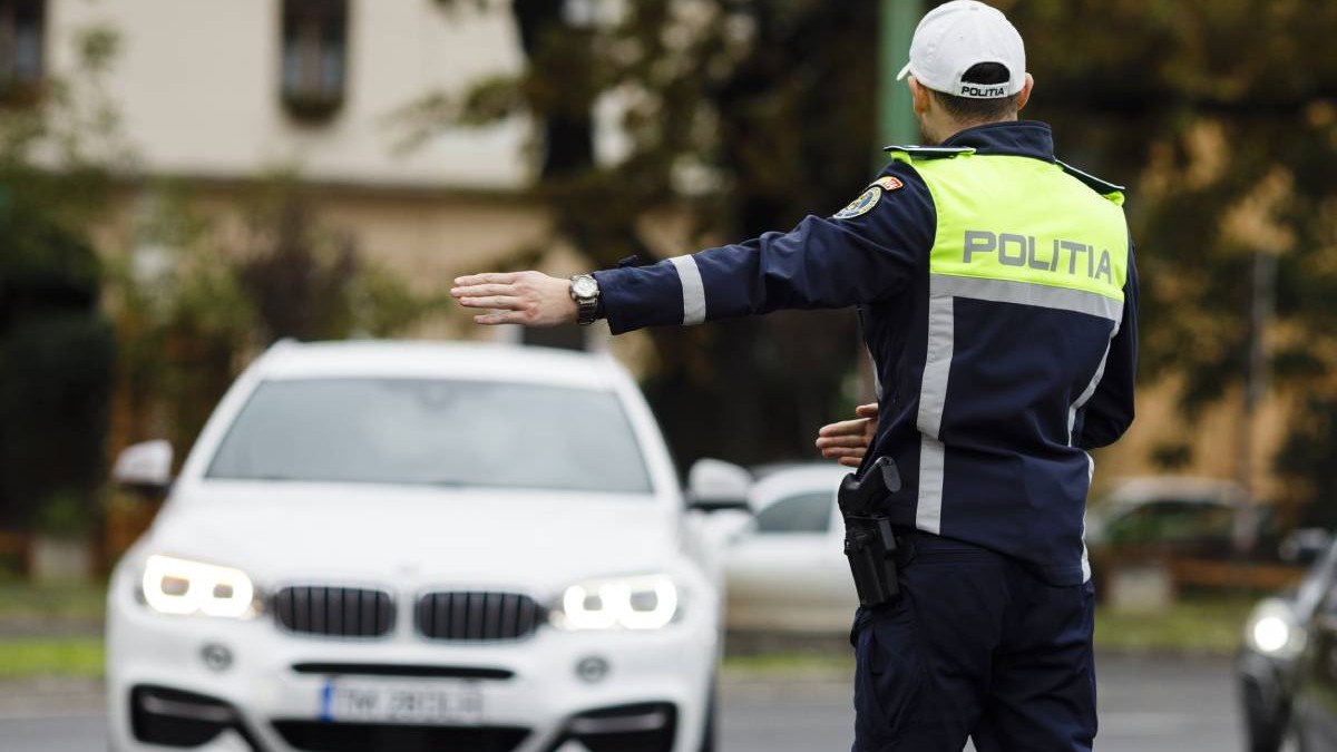 politist imbracat in uniforma in timp ce opreste o masina in trafic
