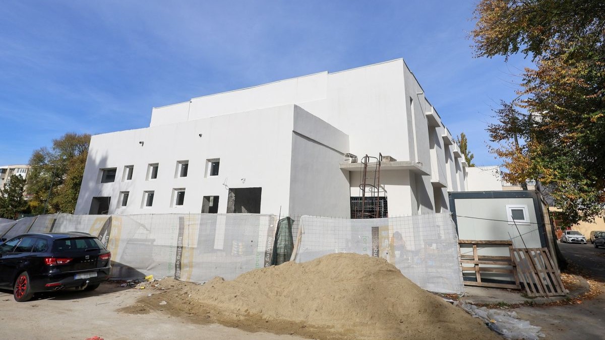 Clădirea fostului cinematograf Flacăra din Galați în stare de degradare, se mai vede doar o clădire albă în construcție. Ea va fi renovată, în fața ei este un morman de nisip și o mașină, octombrie 2025