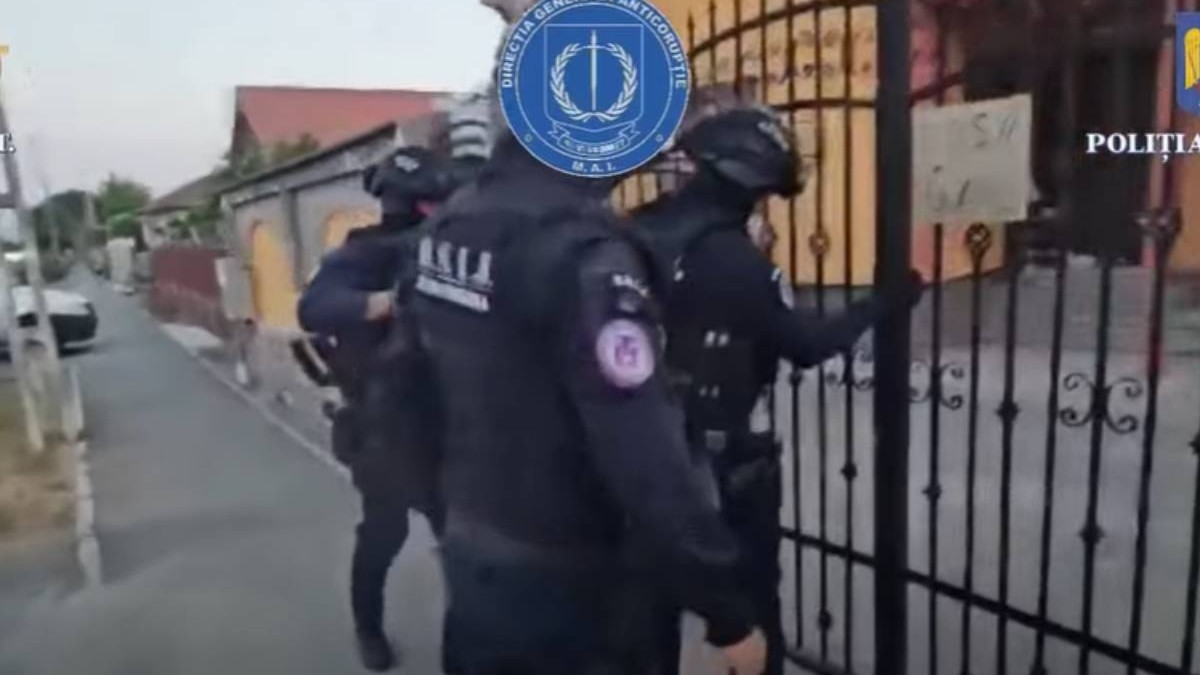 Imagine cu trei jandarmi care se pregătesc să intre în locuința polișistului din Moreni