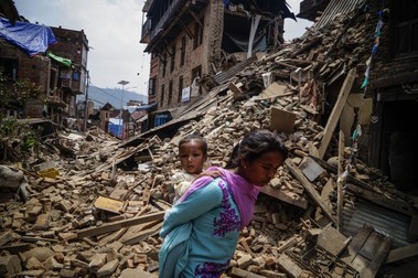 A Nepalese woman carring her child walks past the collapse building in Sankhu village in, Kathmandu, Nepal on May 16, 2015 following the second major earthquake. The second major earthquake hit Nepal on May 12, 2015 as the country recovers from last month's devastating earthquake, in Nepal. Photo by Sunil Pradhan/AA/ABACAPRESS.COM