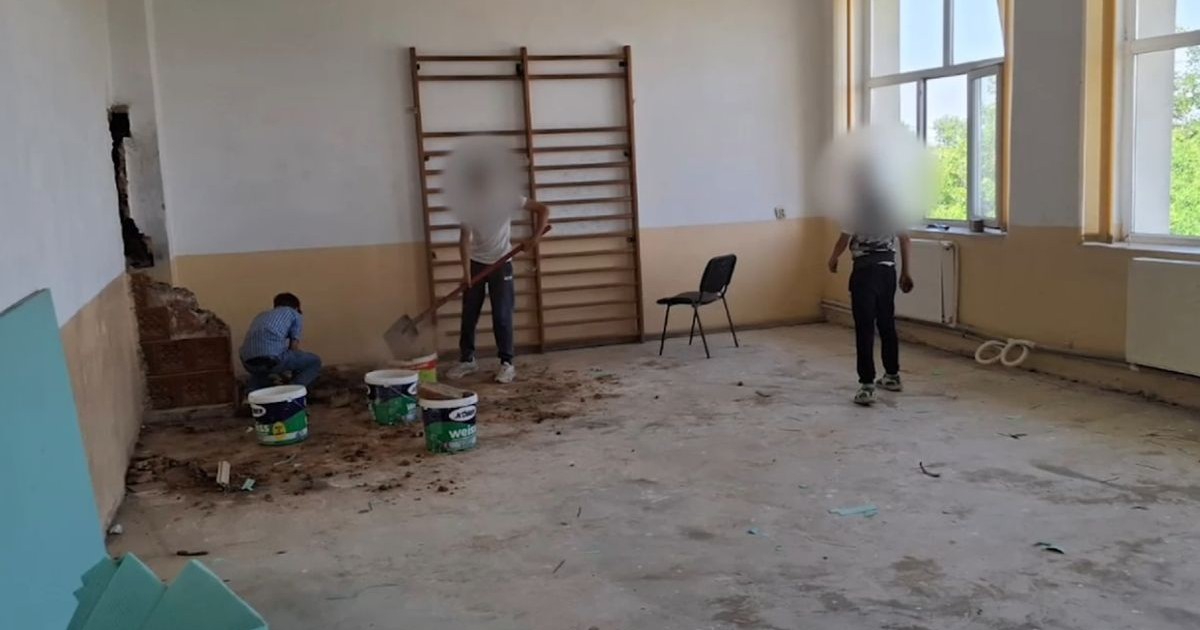 Doi elevi cu fețele blurate ajută la reperații în sala de sport a unei școli, iar un altul este cu spatele și lângă ei sunt găleți de materiale de construcții, în Dolj