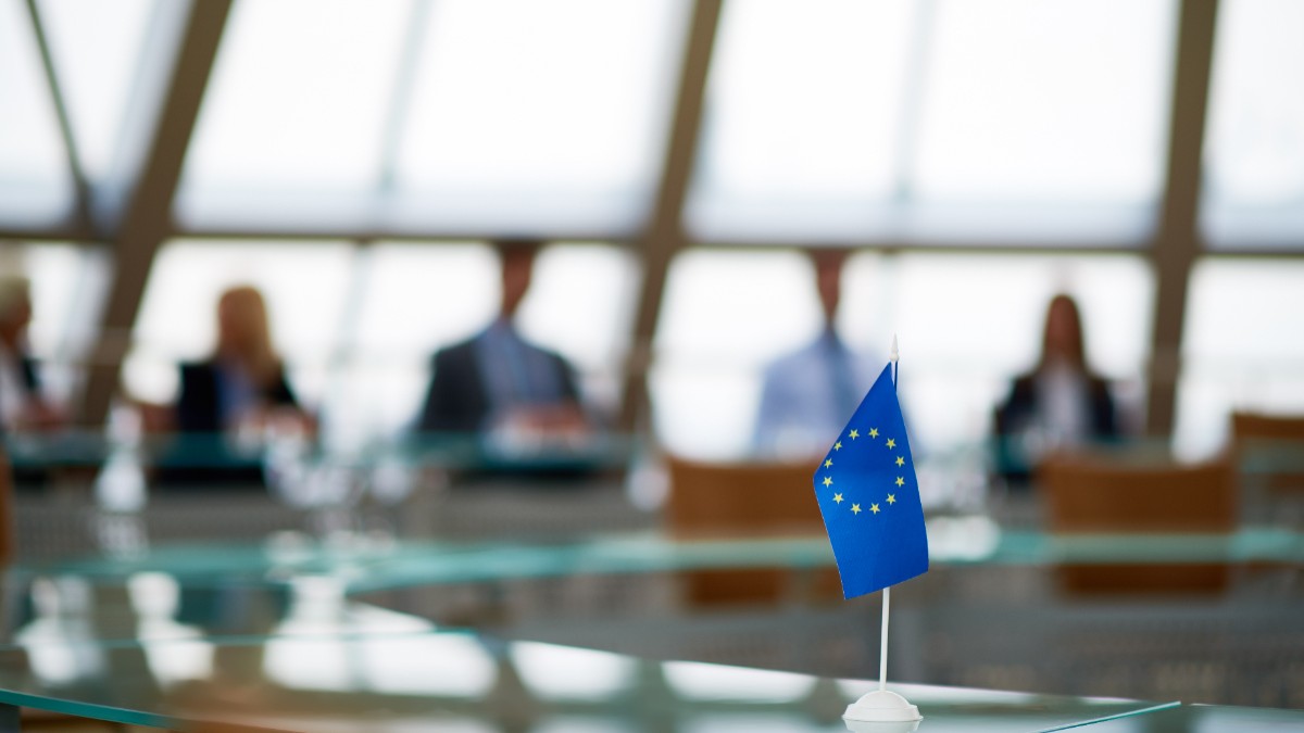 Un steag al Uniunii Europene, așezat pe o masă, într-o sală de ședințe