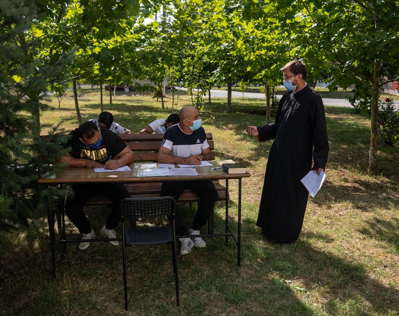 Preotul care îi învață alfabetul pe deținuții de la Jilava și le dă teme de făcut în celulă. „Daniel scrie cel mai frumos, așa îmi pare mie”
