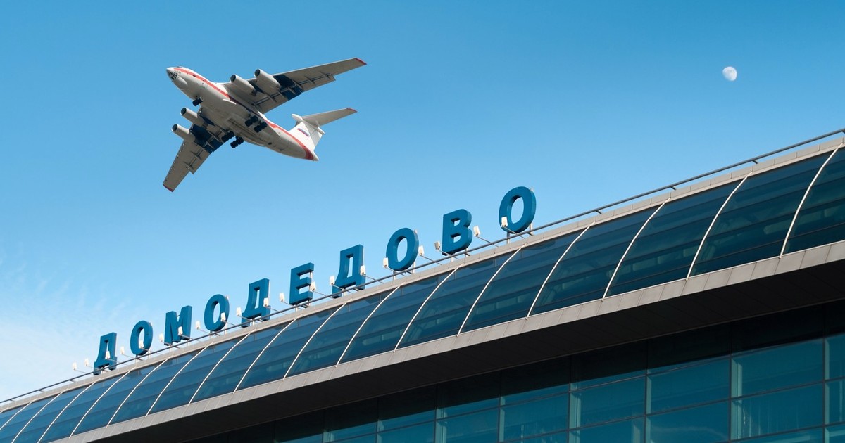 Exteriorul clădirii aeroportului internațional din Moscova și un avion zburând pe cerul albastru. Domodedovo. Rusia