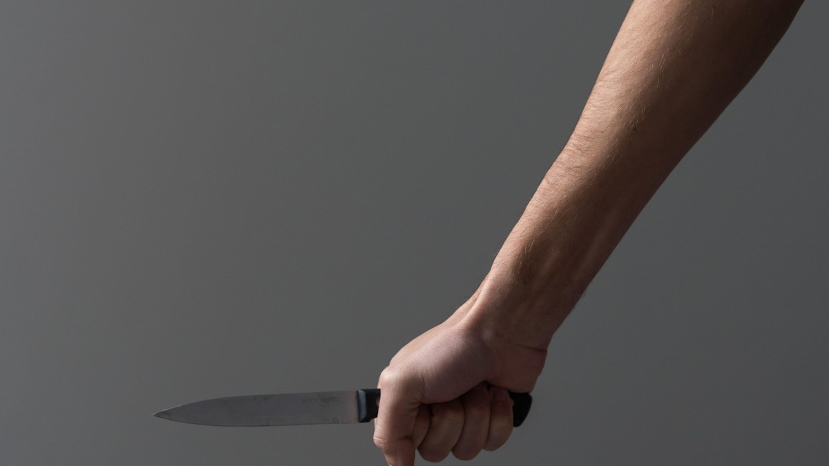 Imagine cu mâna unui bărbat în care se află un cuțit
