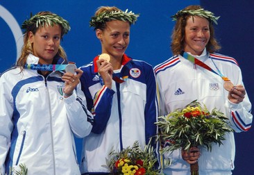 epa000253589 Camelia Potec from Romania (C) shows off her gold medal, sided by silver medalist Federica Pellegrini (L) from Italy and Solenne Figues from France, who took bronze after the women's 200m Freestyle final at the Athens Olympic Aquatic Centre, Tuesday 17 August 2004. epa/dpa Kay Nietfeld EPA/Kay Nietfeld