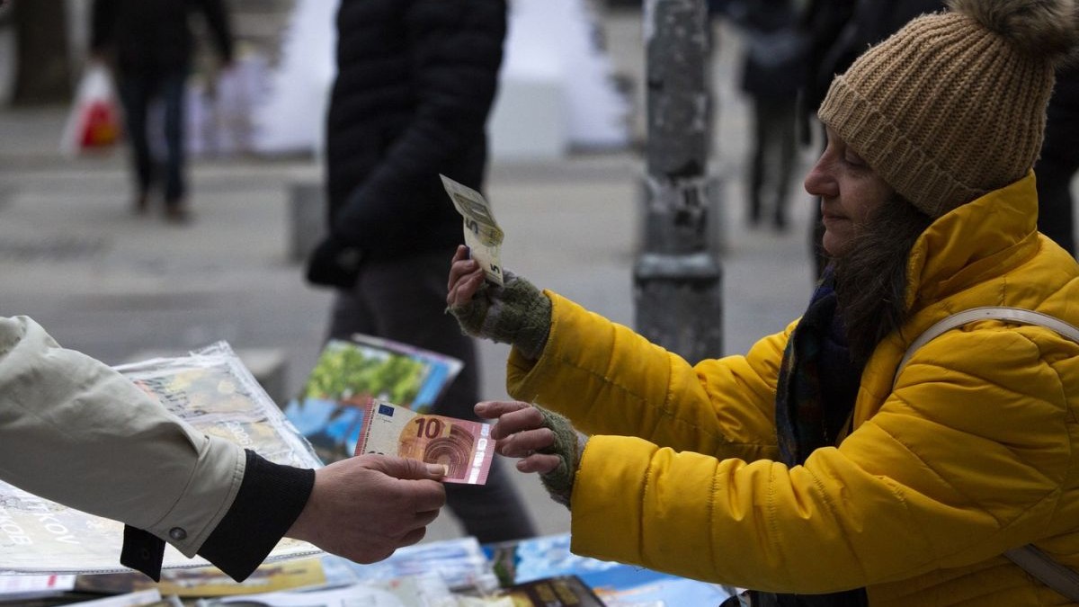 O vânzătoare ambulantă din Sofia, Bulgaria, primește de la un client o bancnotă de 10 euro și dă rest una de 5 euro, 1 ianuarie 2026