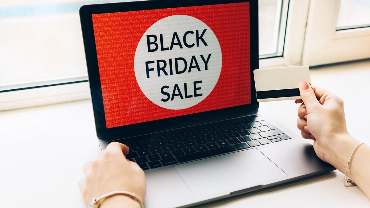Close-up mâini femeie cu card de credit oferte de Black friday pe laptop