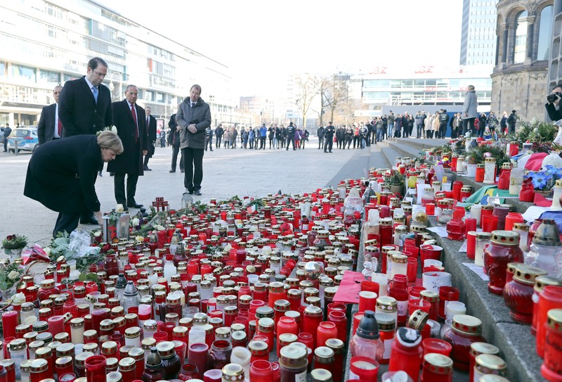 epa05792739 German Chancellor Angela Merkel (L) and Tunisian Prime Minister Youssef Chahed (3R) visit the place of the Christmas market terrorist attack at Breidscheidplatz in Berlin, Germany, 14 February 2017. On 19 December 2016, an IS supporter drove a truck into a crowd killing 12 people. EPA/OLIVER WEIKEN