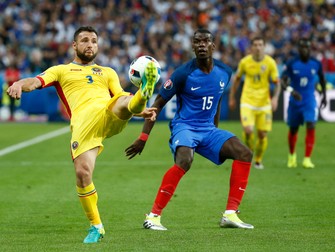 epa05355774 Razvan Rat of Romania (L) in action against Paul Pogba (C) of France during the UEFA EURO 2016 group A preliminary round match between France and Romania at Stade de France in Saint-Denis, France, 10 June 2016. (RESTRICTIONS APPLY: For editorial news reporting purposes only. Not used for commercial or marketing purposes without prior written approval of UEFA. Images must appear as still images and must not emulate match action video footage. Photographs published in online publications (whether via the Internet or otherwise) shall have an interval of at least 20 seconds between the posting.) EPA/YOAN VALAT EDITORIAL USE ONLY