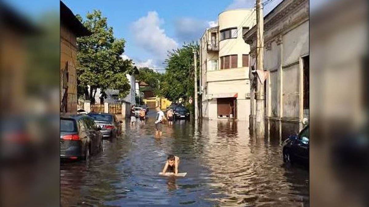 Doi copii s-au bălăcit pe o stradă inundată în București după ploaie