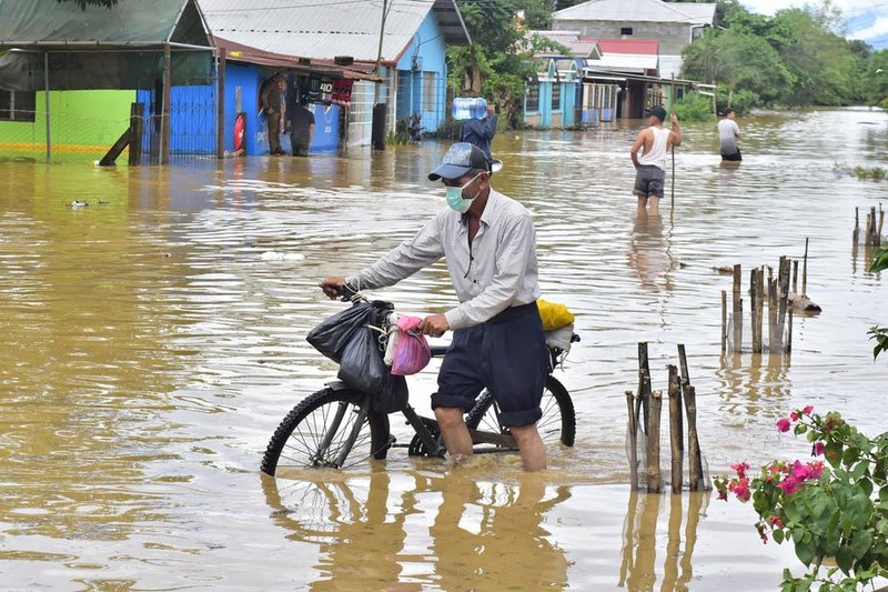 Un bărbat și-a părăsit casa inundată din cauza ploilor abundente din departamentul Yoro, Honduras, luând cu el bicicleta și câteva bunuri FOTO: EPA-EFE/JOSE VALLE