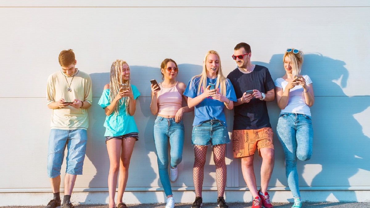 Grup de tineri care își folosesc telefoanele mobile