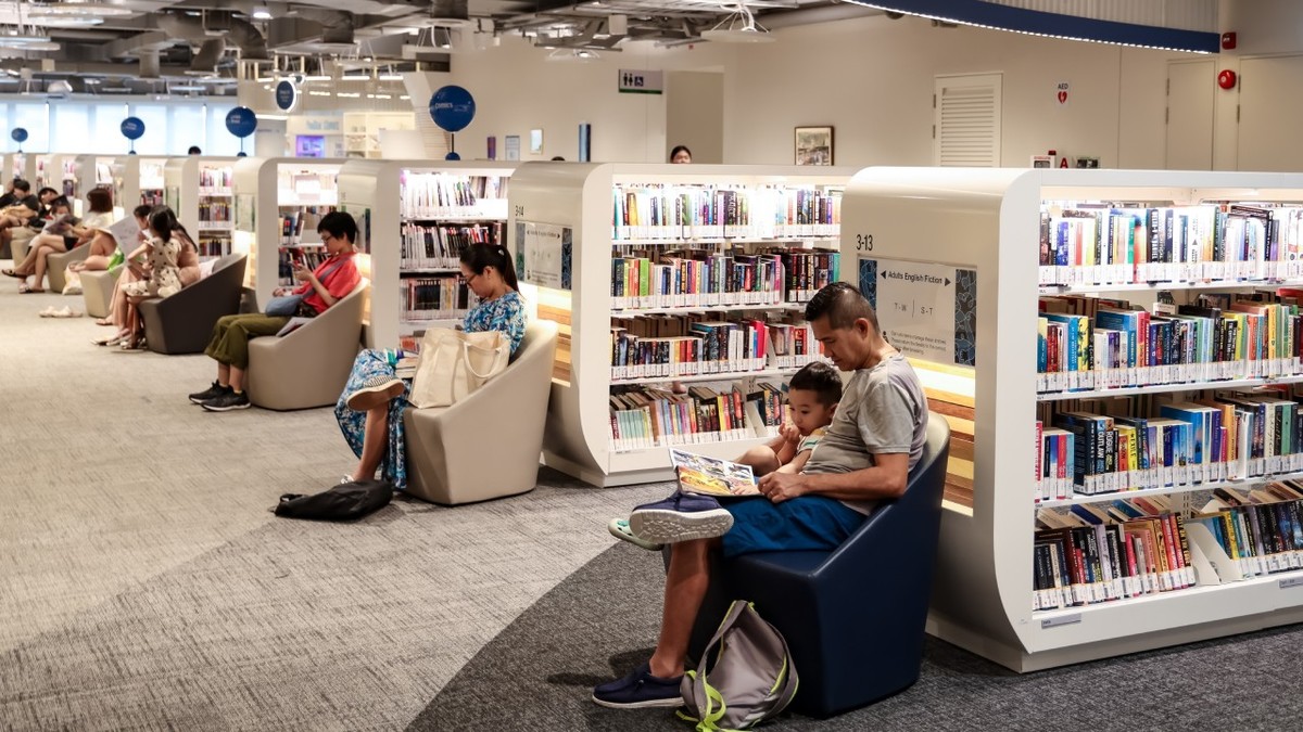 SINGAPORE – 6 OCT 2024: Un tată îi citește fiului său la Biblioteca Punggol.