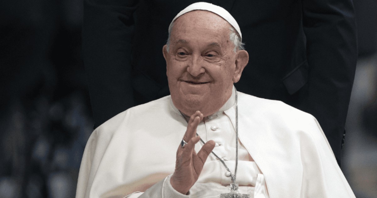 În imagine este ilustrat Papa Francisc, în timp ce ține mâna dreaptă ridicată