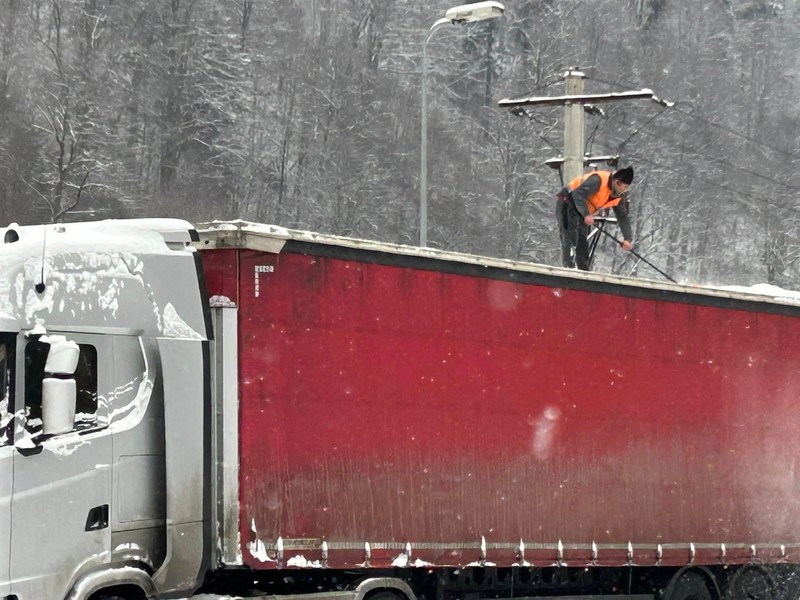 Șofer de TIR din Ilfov surprins în timp ce îndepărtează zăpada de pe semiremorcă. Foto Facebook/InfoCamioane