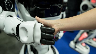 A woman shaking hands with a robot