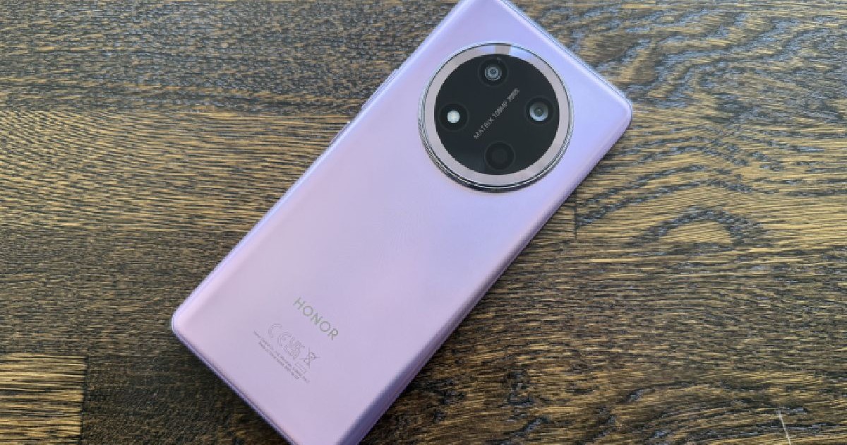 Spatele lila al unui telefon Honor Magic7 Lite pe fundal de lemn.