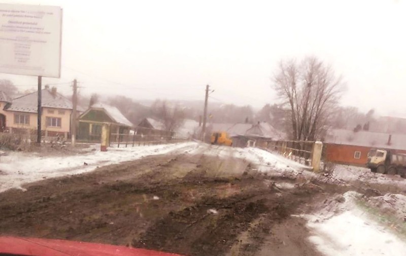 Imagini incredibile surprinse într-un sat din Bistrița. S-a asfaltat un drum în timp ce afară ningea