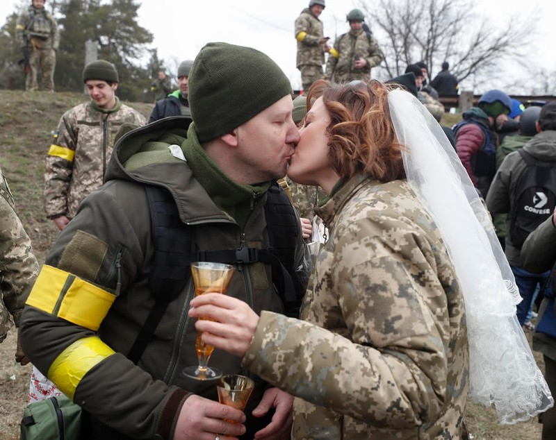 Nuntă pe front. În haine de camuflaj, cu alai înarmat cu flori și puști, doi militari ucraineni s-au căsătorit