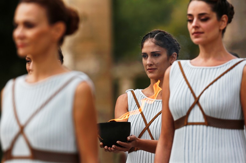 epa06285978 An actress (C), in the role of a priestess, holds an archaic pot with the Olympic Flame during the Lighting Ceremony of the Olympic Flame for the PyeongChang 2018 Winter Olympic Games in front of the Hera Temple in Ancient Olympia, Greece, 24 October 2017. The flame will make a 2,018km journey through South Korea starting on 01 November 2017. The PyeongChang 2018 Winter Olympics will be held from 09 until 25 February 2018. EPA-EFE/YANNIS KOLESIDIS
