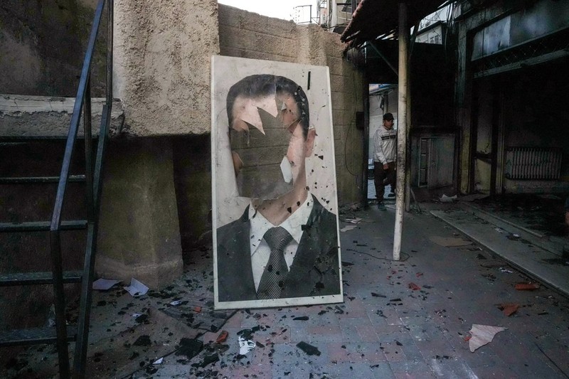 Foto: Afiș al președintelui sirian Bashar al-Assad distrus de rebeli. Sursa: Profimedia