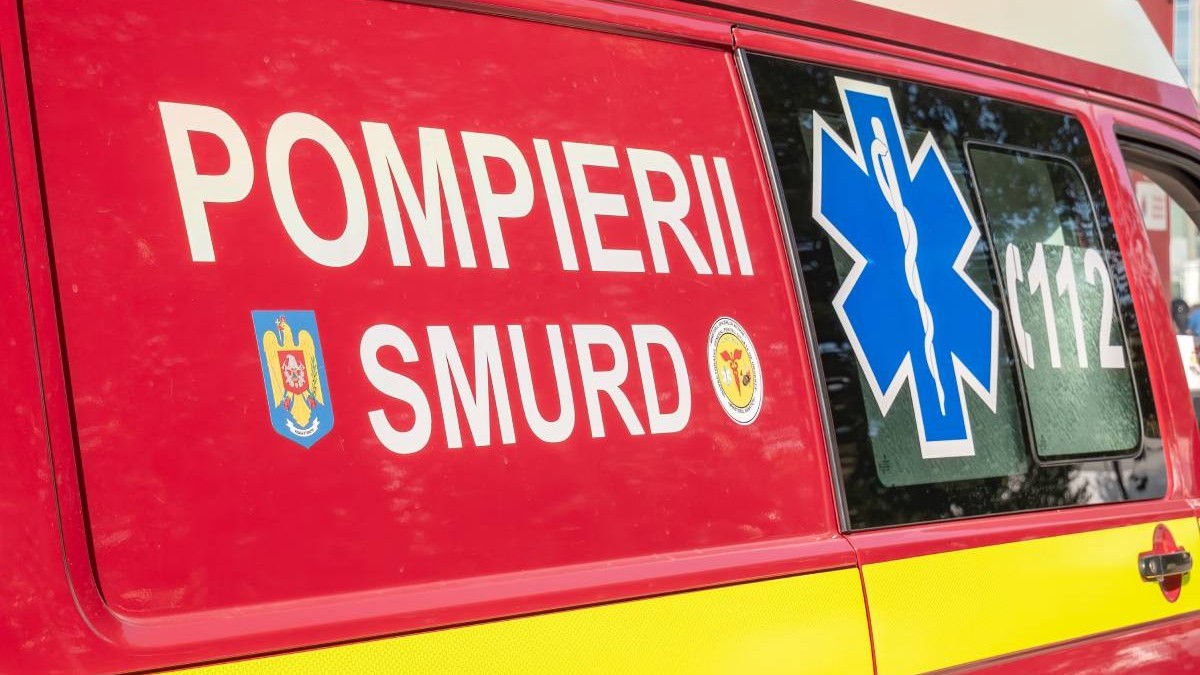 O ambulanță SMURD pe care scrie „POMPIERII SMURD”, este roșie cu însemnul numărului de urgență 112